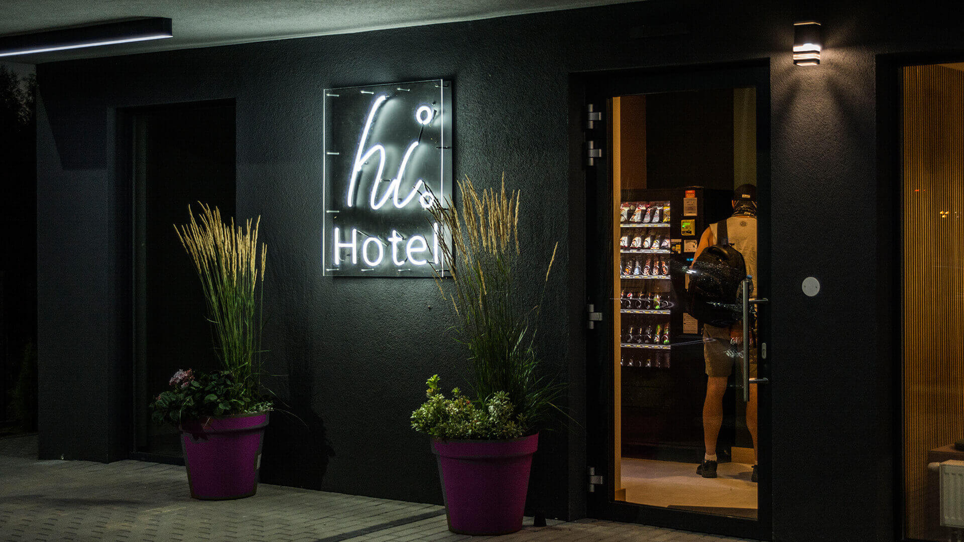 Hallo Hotel HiHotel - hi-hotel-an-der-Wand-an-der-Hinterwand-an-unter-dem-Licht-an-dem-Eingang-an-der-Höhe-an-den-Linien-an-der-Farbe-weißes-Logo-an-der-Firma-an-dem-Beton-gdansk-lotnisko (48)